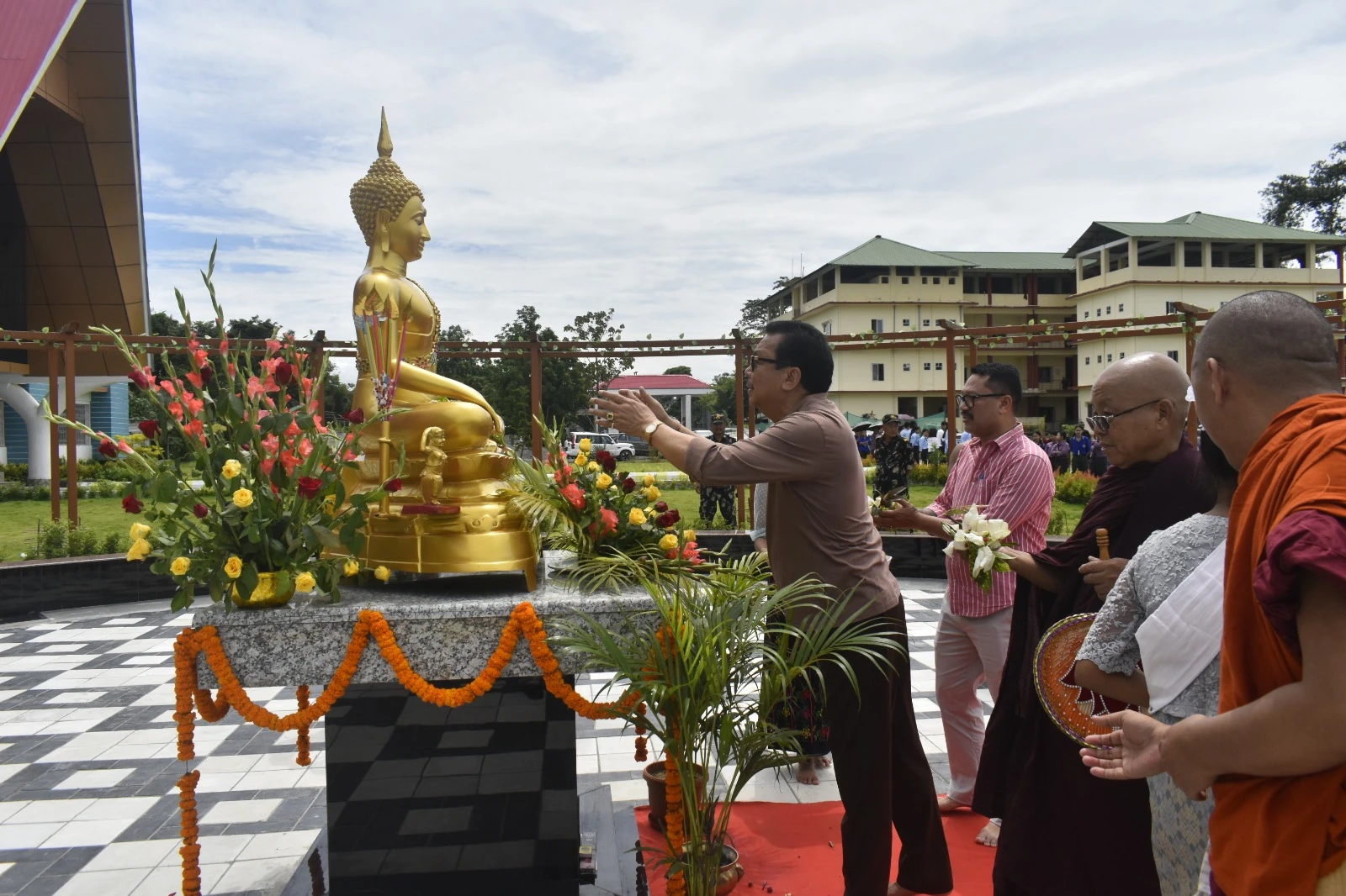 A ceremony beside the Buddha statue in the college courtyard